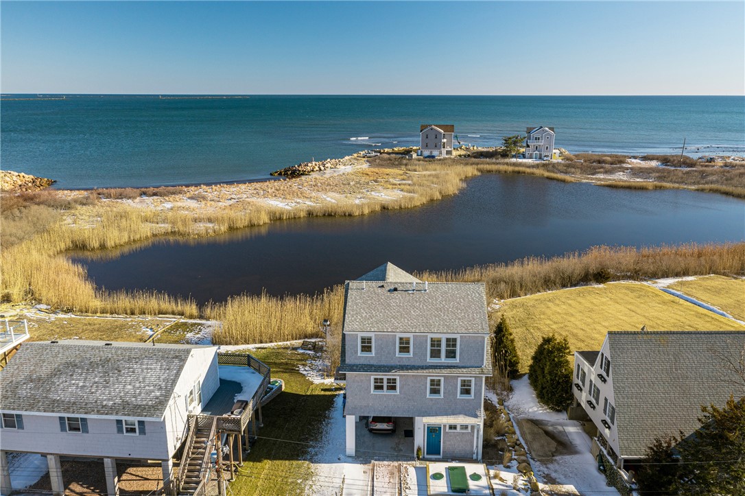 Aerial view of a coastal home between a salt pond and the ocean.