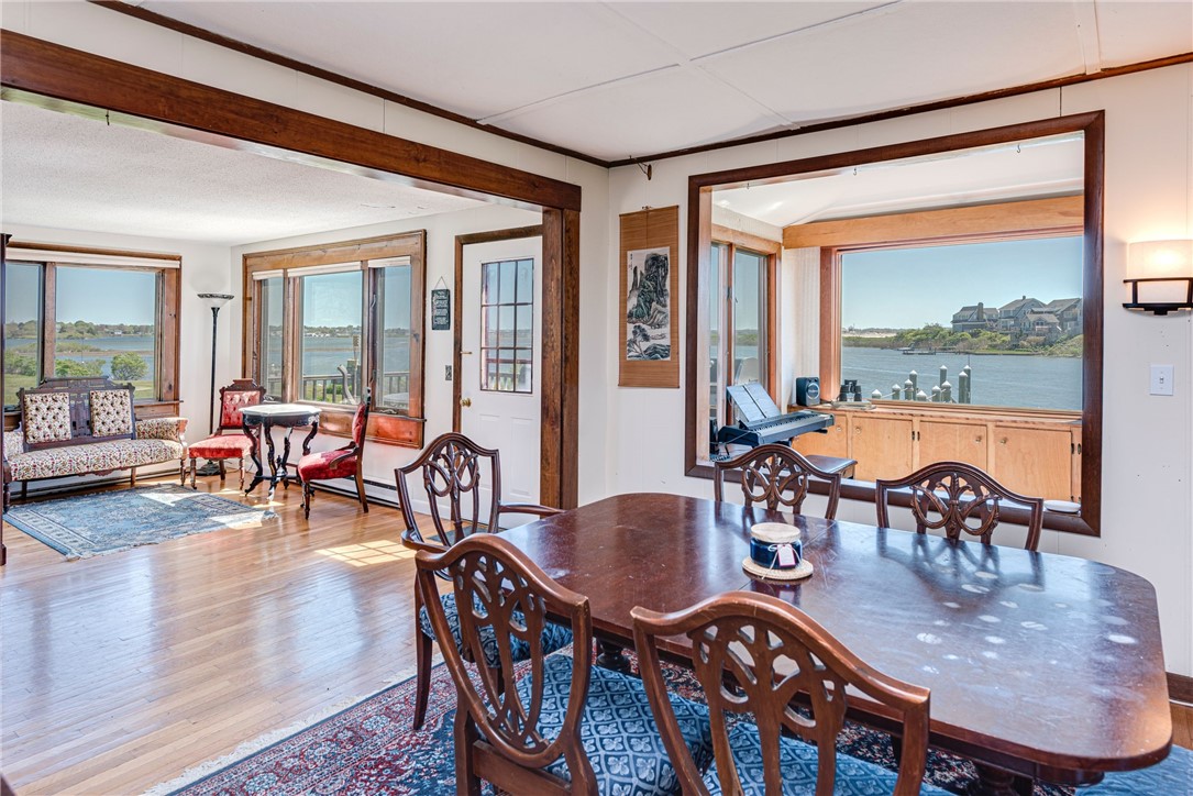 Dining room with carved wood chairs and broad windows overlooking the water.