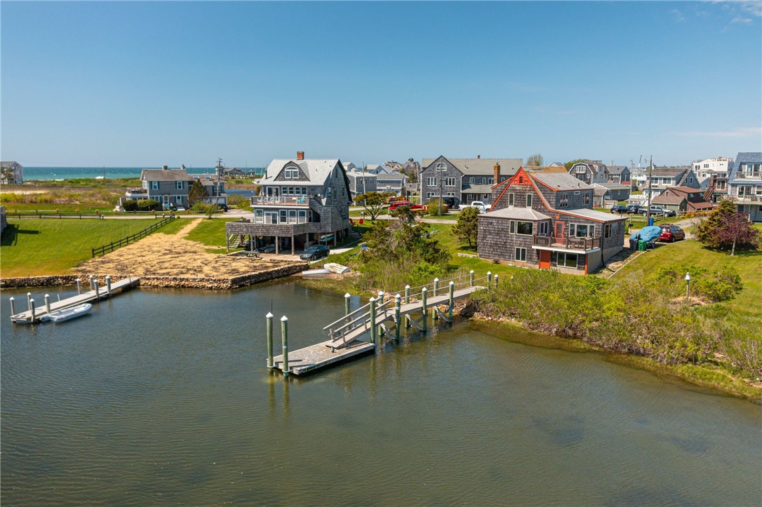 Waterfront homes beside an inlet, with private docks and the ocean beyond.