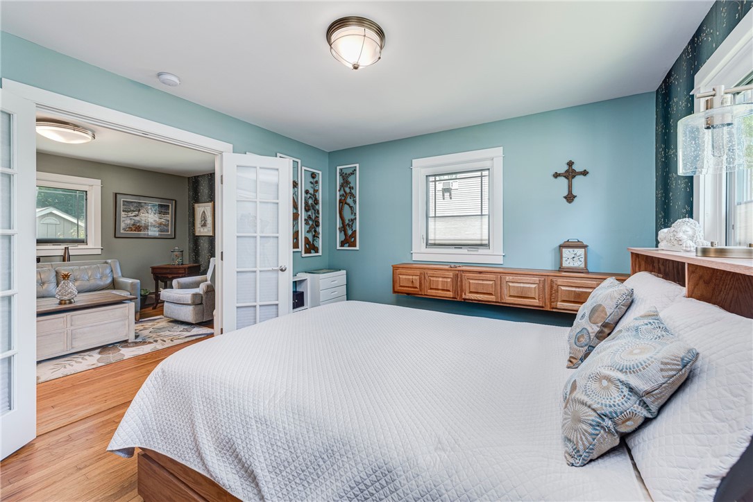 Bedroom with blue walls, built-in wooden drawers, and French doors to an adjoining sitting room.