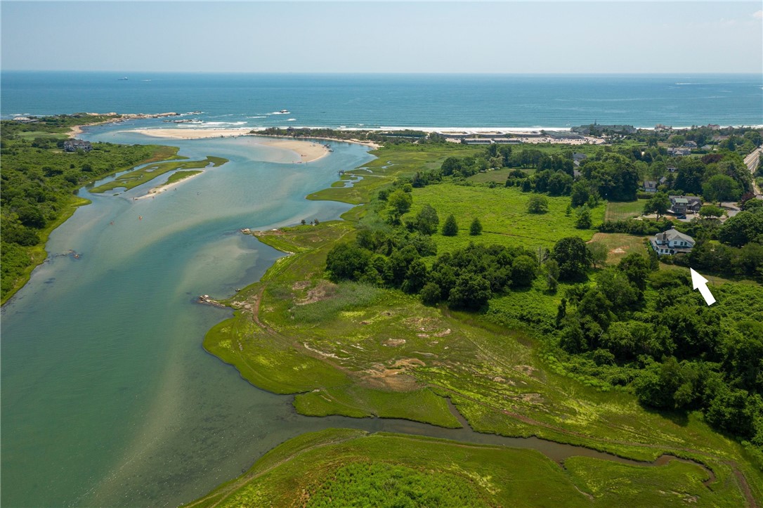 Aerial view of coastal property beside salt marsh, with an arrow marking the house.