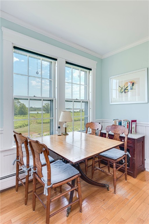 Dining room with a wooden table and chairs beside two tall windows.