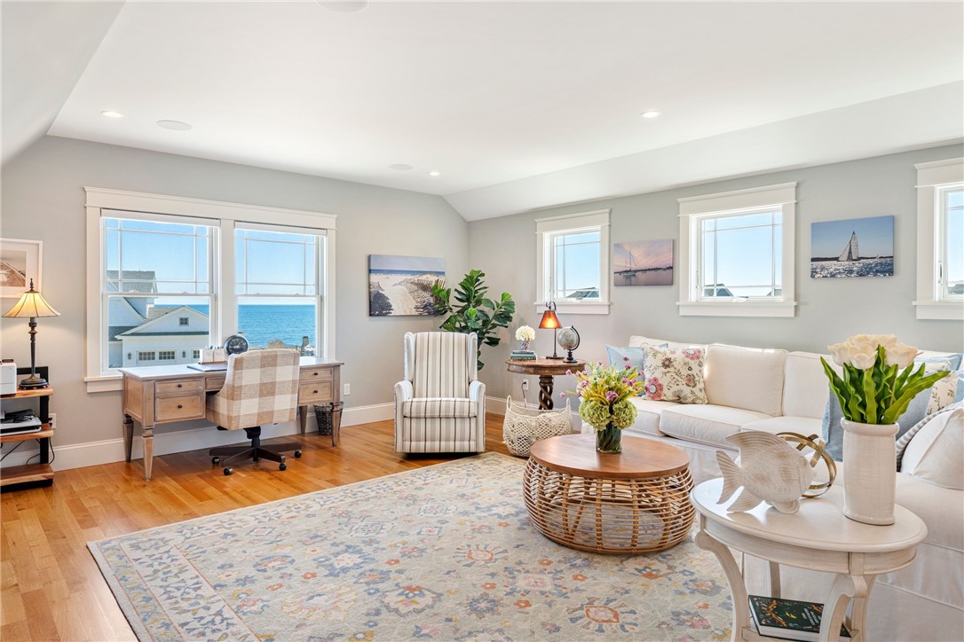 Living room with white sofas and large windows overlooking the ocean.