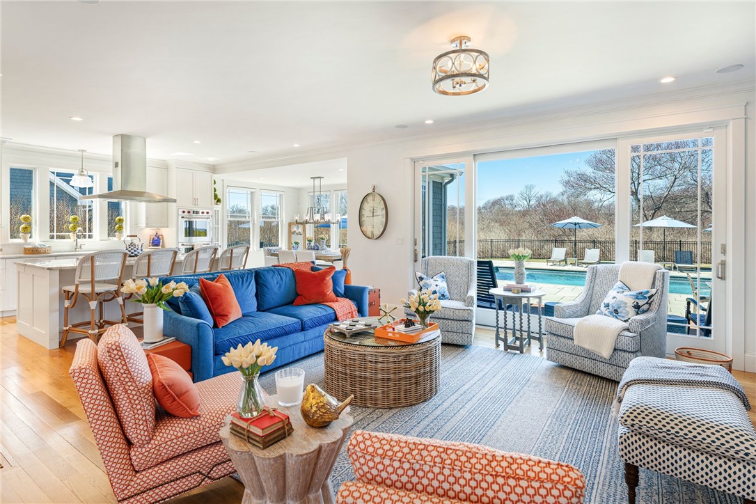 Furnished living room with a blue sofa and sliding doors overlooking a swimming pool.