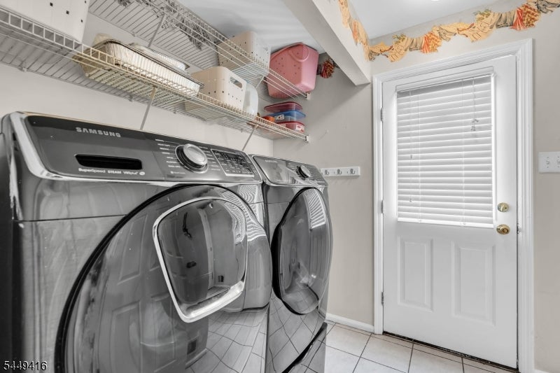 Laundry room with matching front-load washer and dryer beneath wire shelves, beside a white door with blinds.