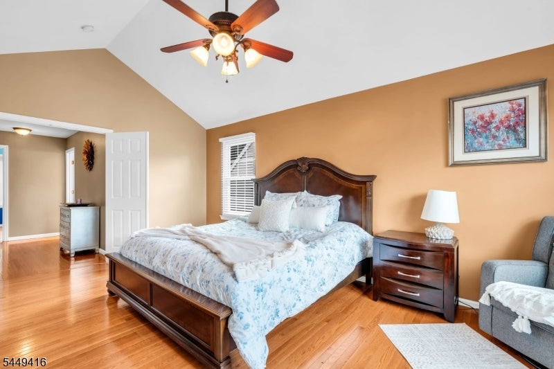 Bedroom with a dark wood bed, pale blue floral bedding, and warm wood floors.