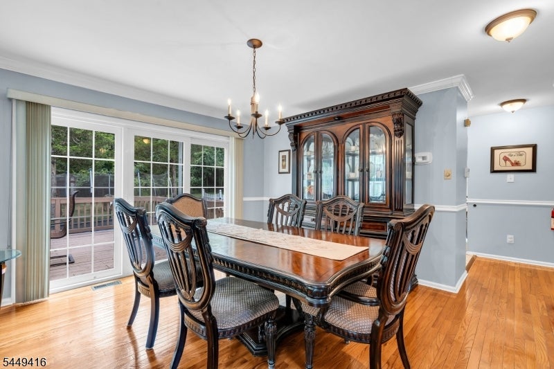 Dining room with a dark wood table, glass-front china cabinet, and sliding doors to a deck.
