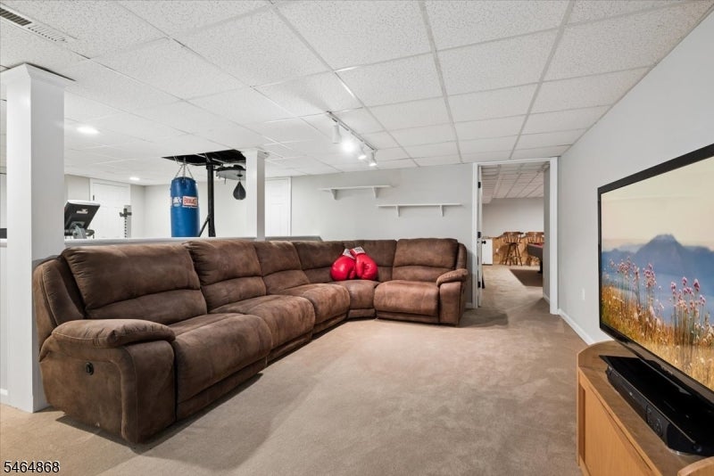 Basement family room with a brown sectional sofa, television, and a punching bag.
