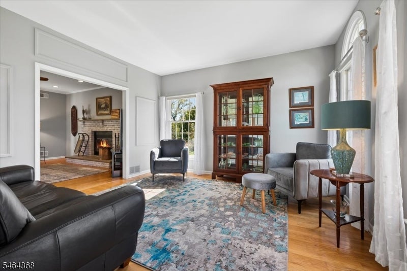 Living room with a brick fireplace visible through the open doorway and a glass-front wooden cabinet.