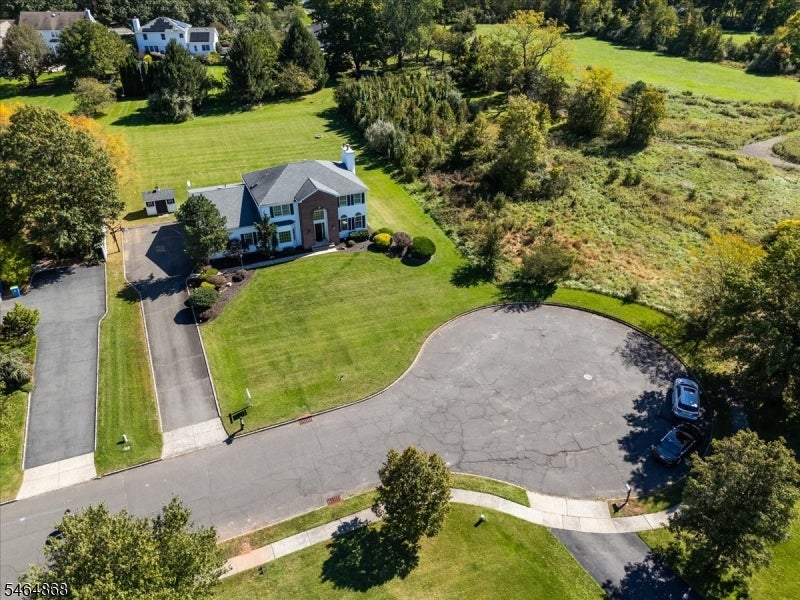 Aerial view of a two-story home beside a cul-de-sac and broad green lawn.