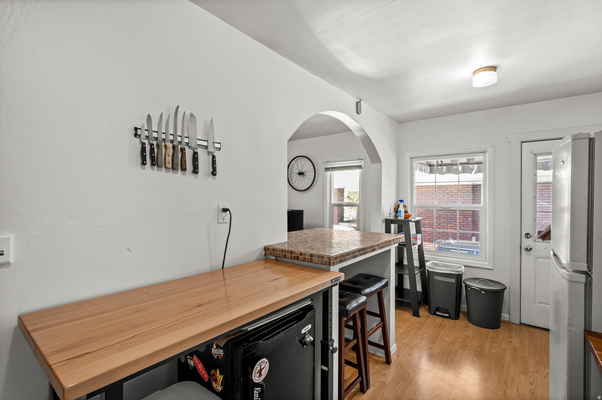 Kitchen with butcher-block counters, a wall-mounted knife rack, and brewing equipment.