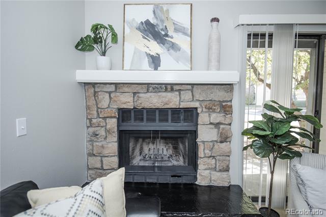 Living room fireplace with a stone surround, white mantel, and framed abstract artwork.