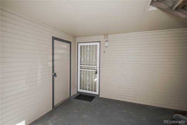 Covered unit entry with a decorative metal security door and number 5.