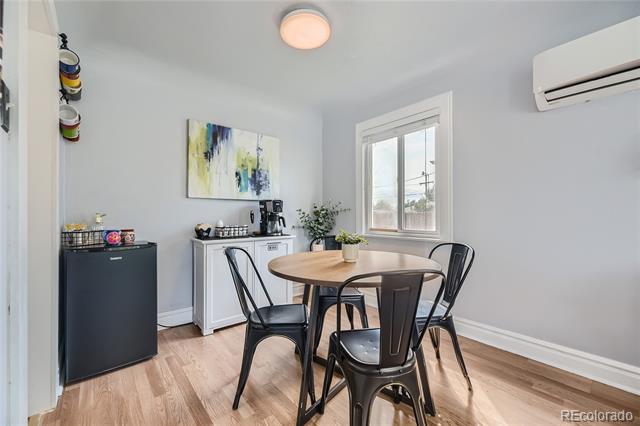 Dining area with a round wooden table, four black chairs, and a window.