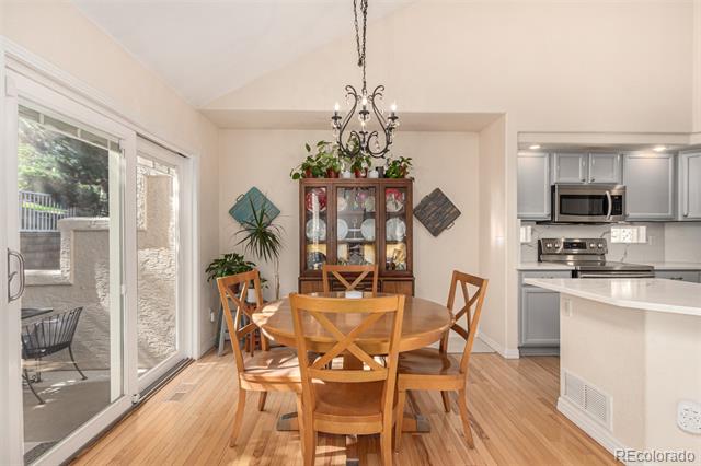 Dining area with a round wooden table, china cabinet, chandelier, and sliding doors to a patio.