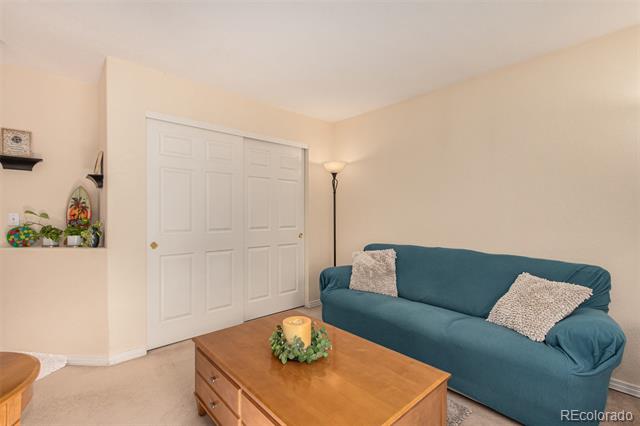 Living room with a teal sofa, wooden coffee table, and white sliding closet doors