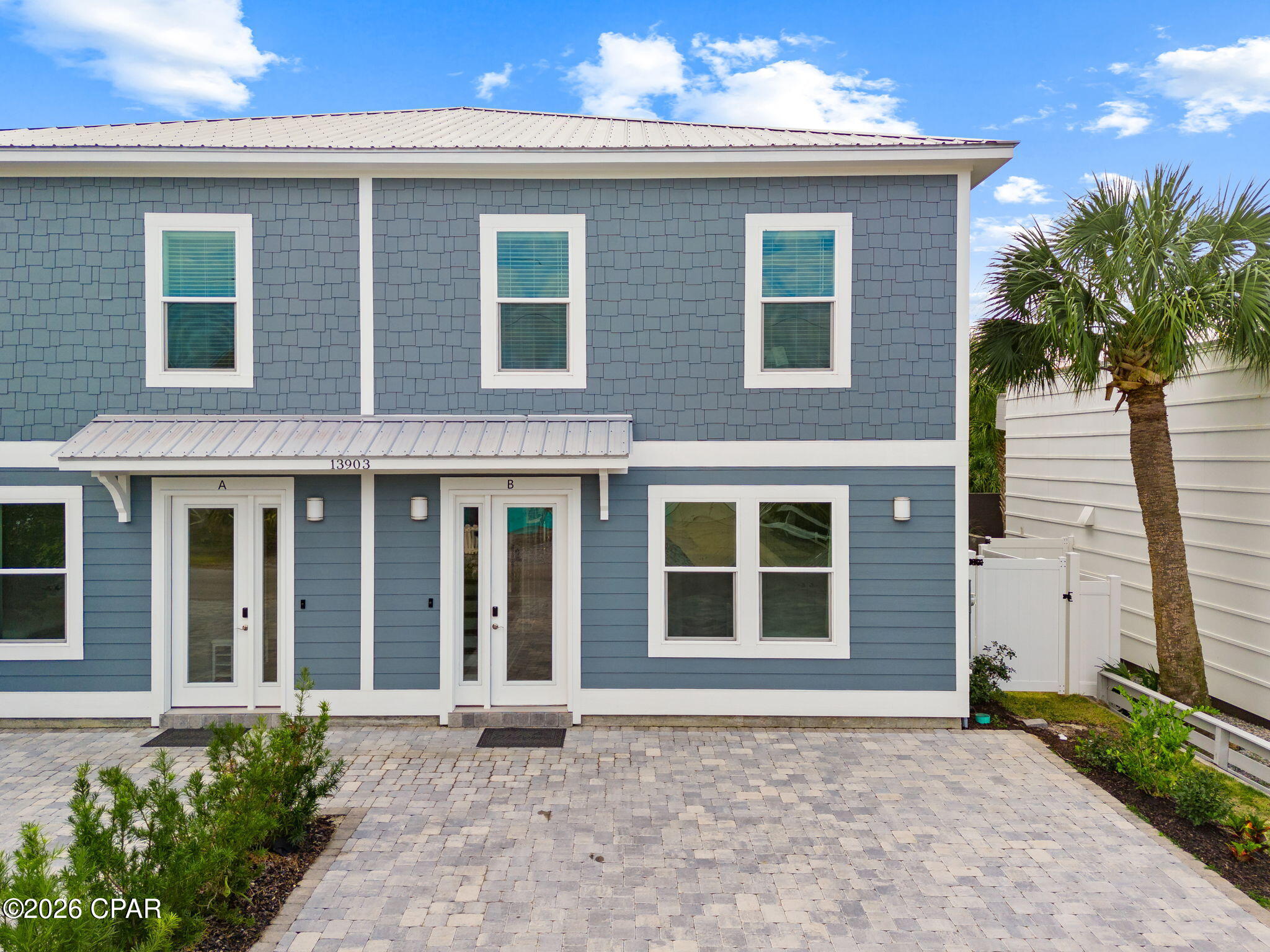 Blue-gray two-story duplex with separate entrances labeled A and B and a paved driveway.