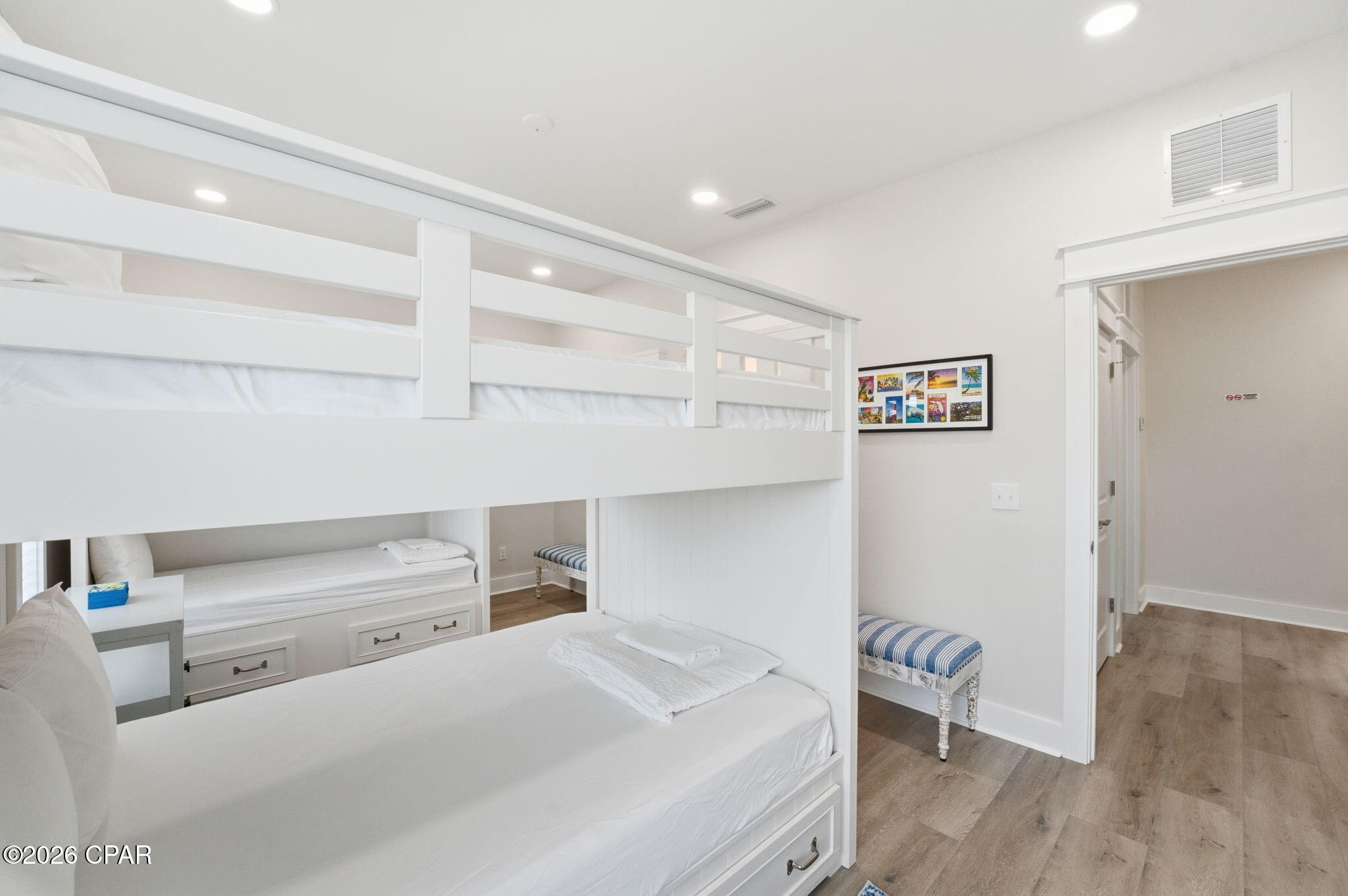 Bedroom with white built-in bunk beds and drawer storage beneath the lower beds.