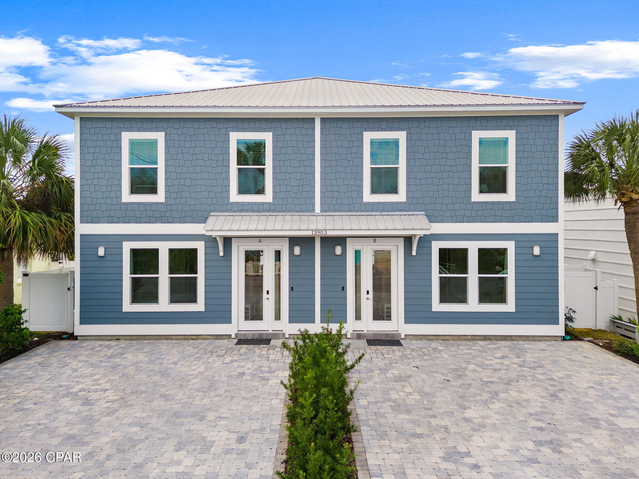 Blue two-story duplex with white trim, separate A and B entrances, and a paved driveway.