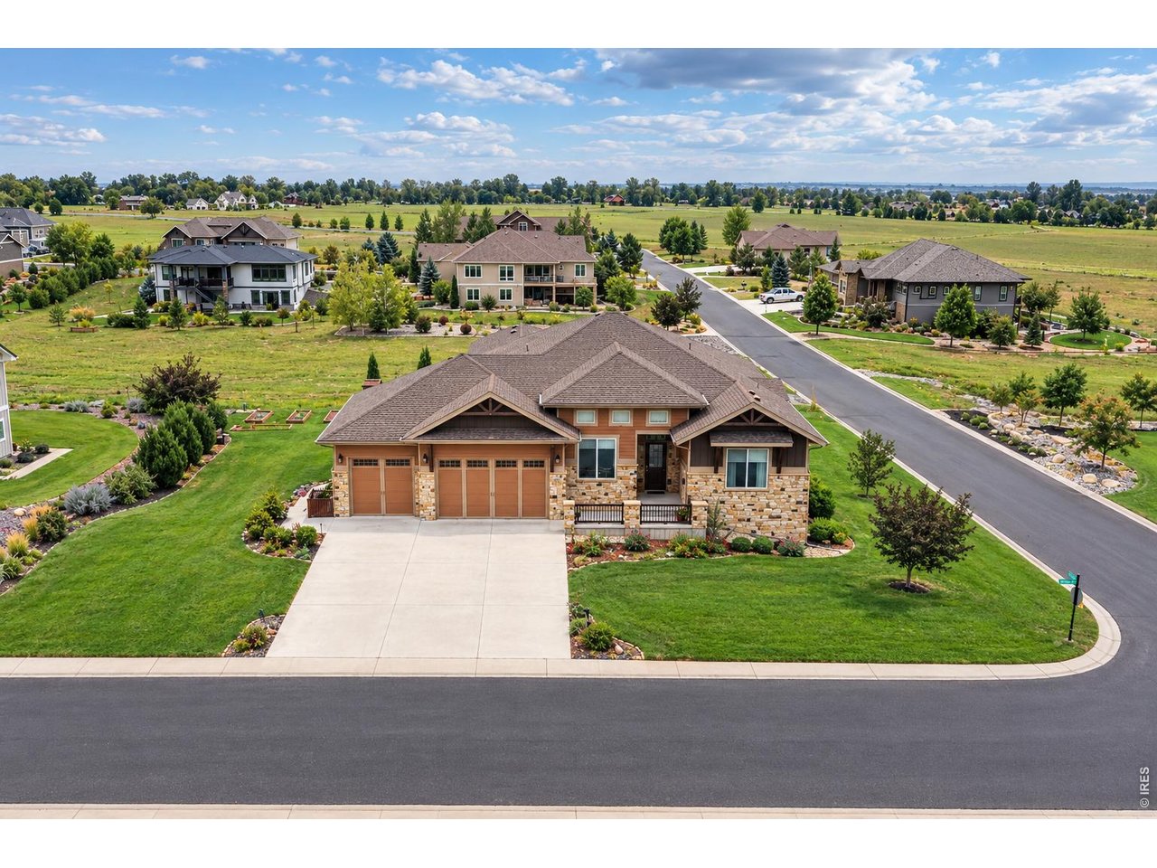 Large stone-and-siding home with a three-car garage on a landscaped corner lot.