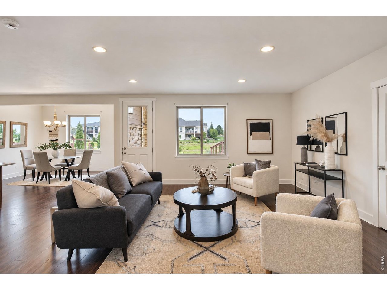 Staged living room with a round coffee table, geometric rug, and adjoining dining area.