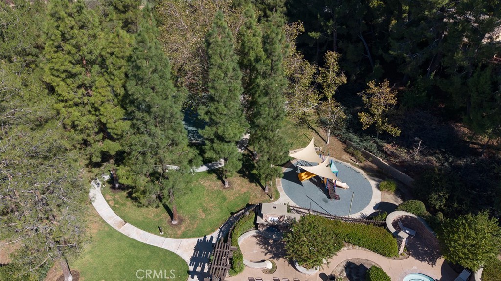 Aerial view of a landscaped playground with shade canopies, walking paths, and mature trees.