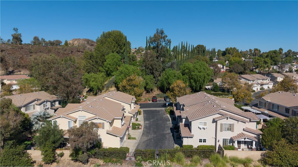 Aerial view of homes along a cul-de-sac below a wooded hillside.