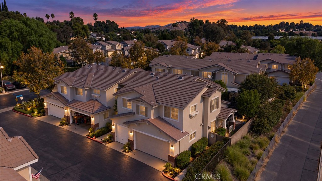 Aerial view of a two-story home in a residential neighborhood at sunset.
