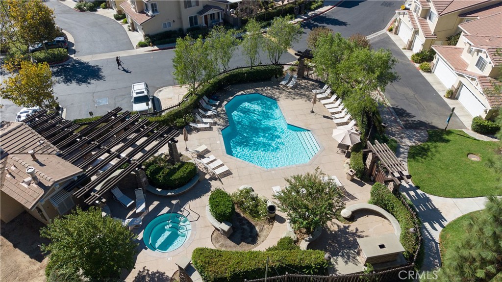 Community pool and spa surrounded by patios, loungers, and landscaping