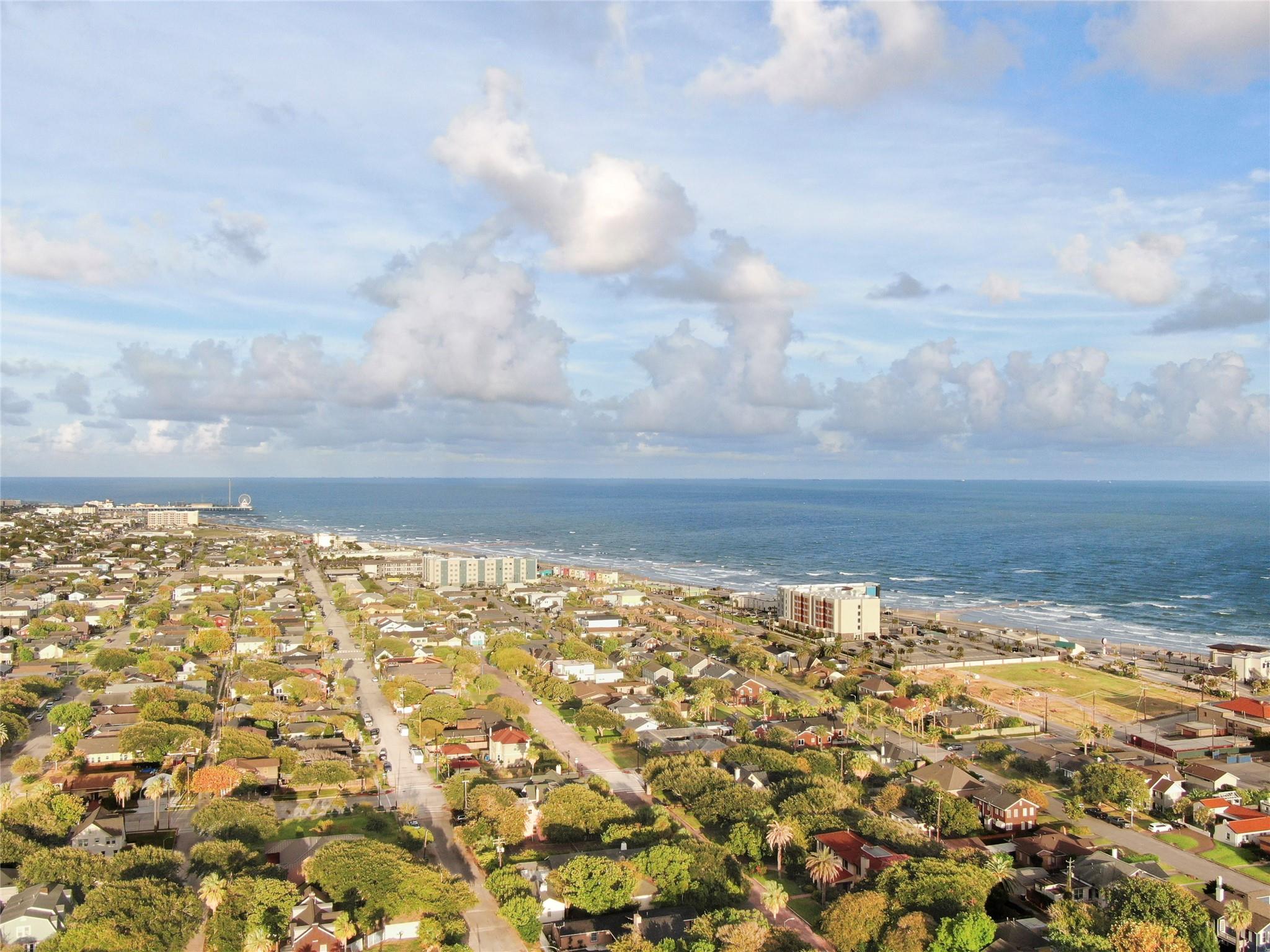 Aerial view of Galveston homes and beachfront buildings beside the Gulf of Mexico.