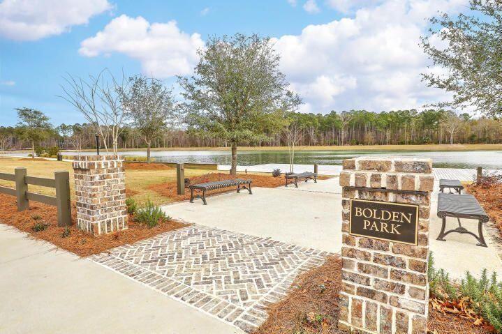 Bolden Park lakeside seating area with benches, brick sign pillars, and a patterned walkway.