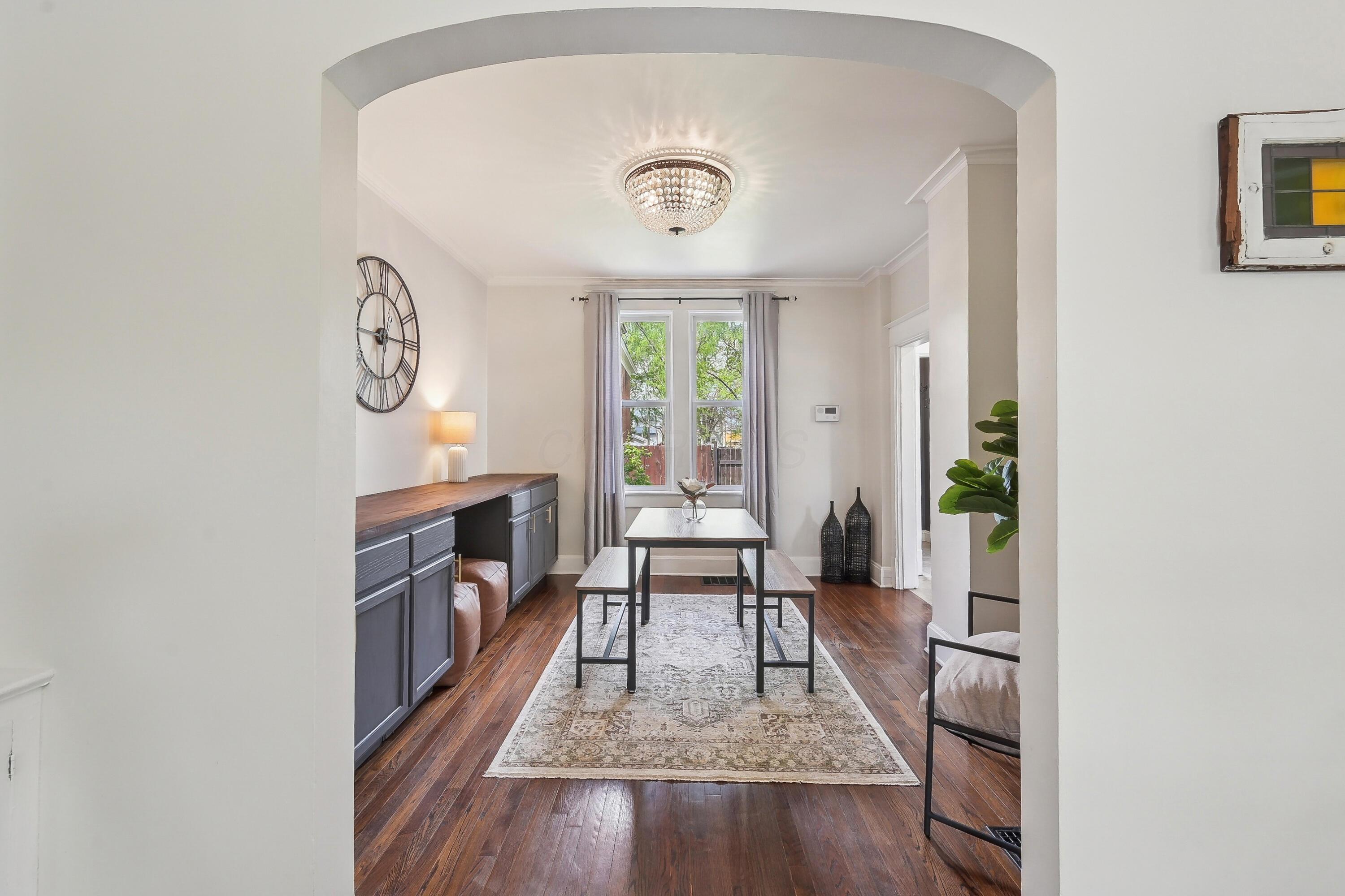 Dining room with a crystal chandelier, dark wood table, built-in sideboard, and hardwood floors.