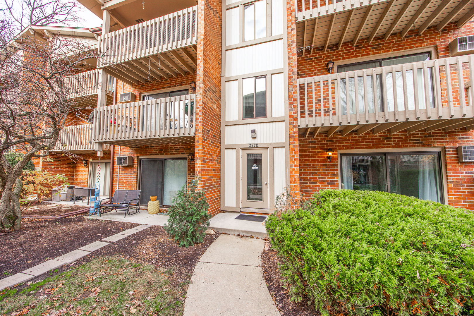 Red-brick condominium exterior with white-railed balconies and an entrance marked 2370.