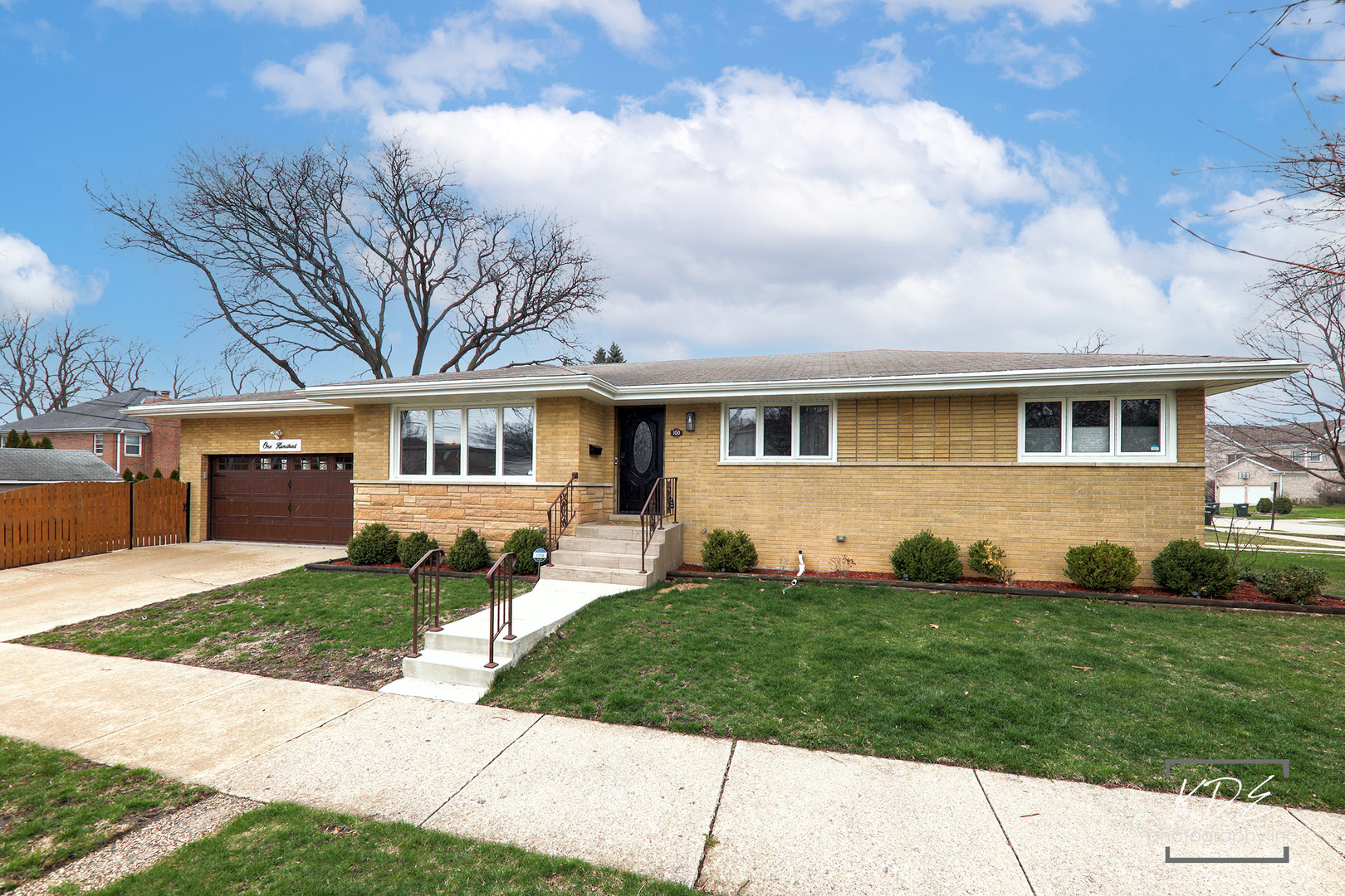 Single-story yellow brick ranch home with an attached garage and front steps.