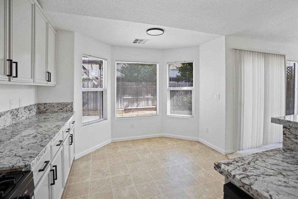 Kitchen with granite counters and a bright windowed dining nook.