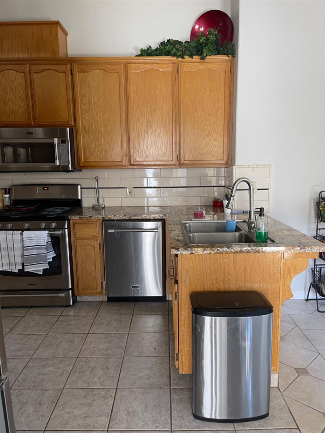 Kitchen with wood cabinets, stainless steel appliances, and a double-basin sink.