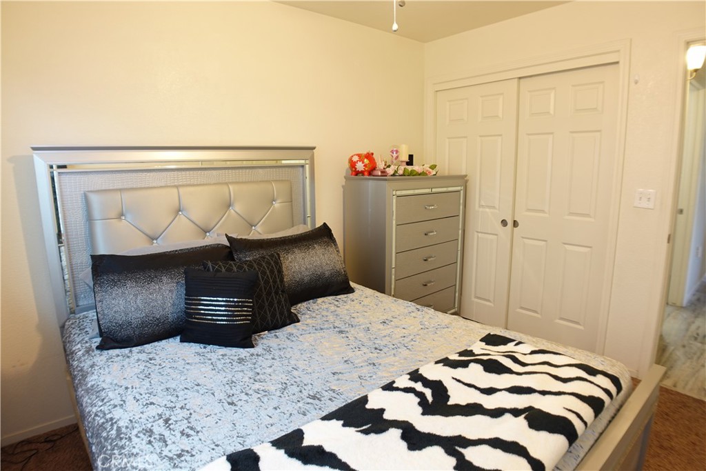 Furnished bedroom with a silver headboard, patterned bedding, and zebra-print throw.