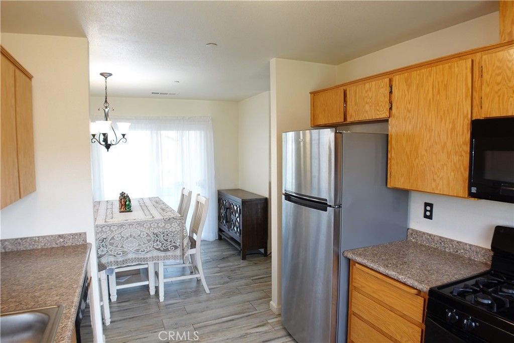 Kitchen with wood cabinets and stainless steel appliances beside a dining area.