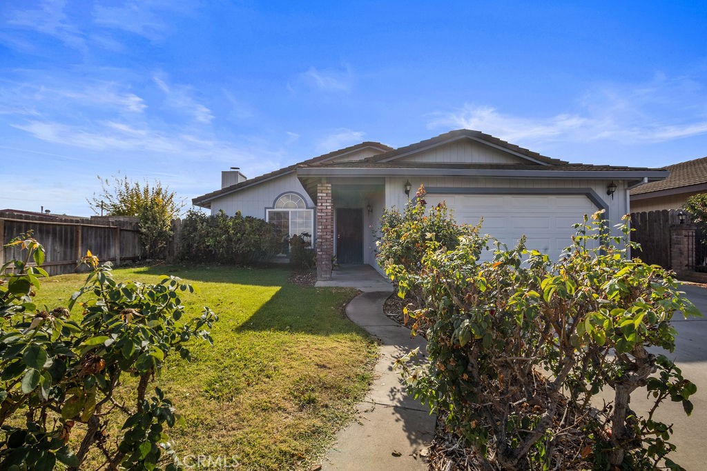 Single-story home with a two-car garage, covered entry, front lawn, and curved walkway.