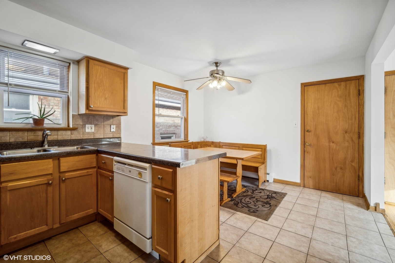 Kitchen with wood cabinets, a peninsula, and a breakfast nook with built-in bench seating.