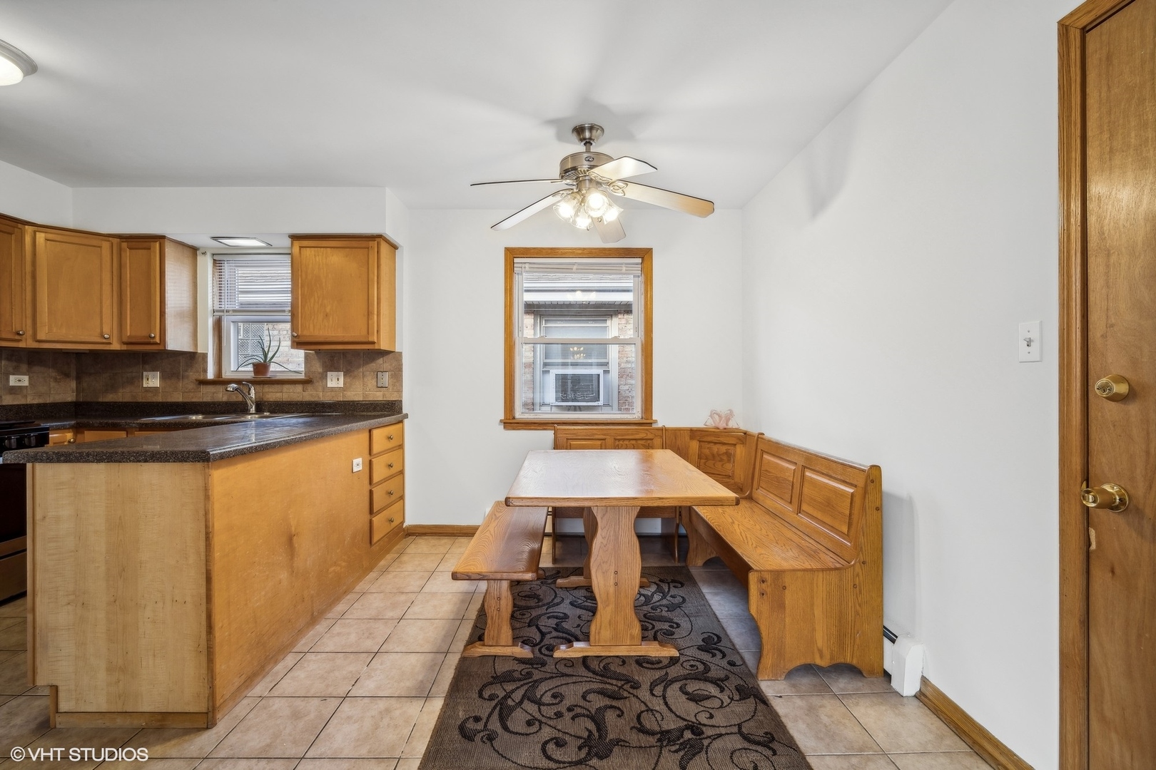 Kitchen and dining nook with wood cabinets and a built-in wooden banquette.