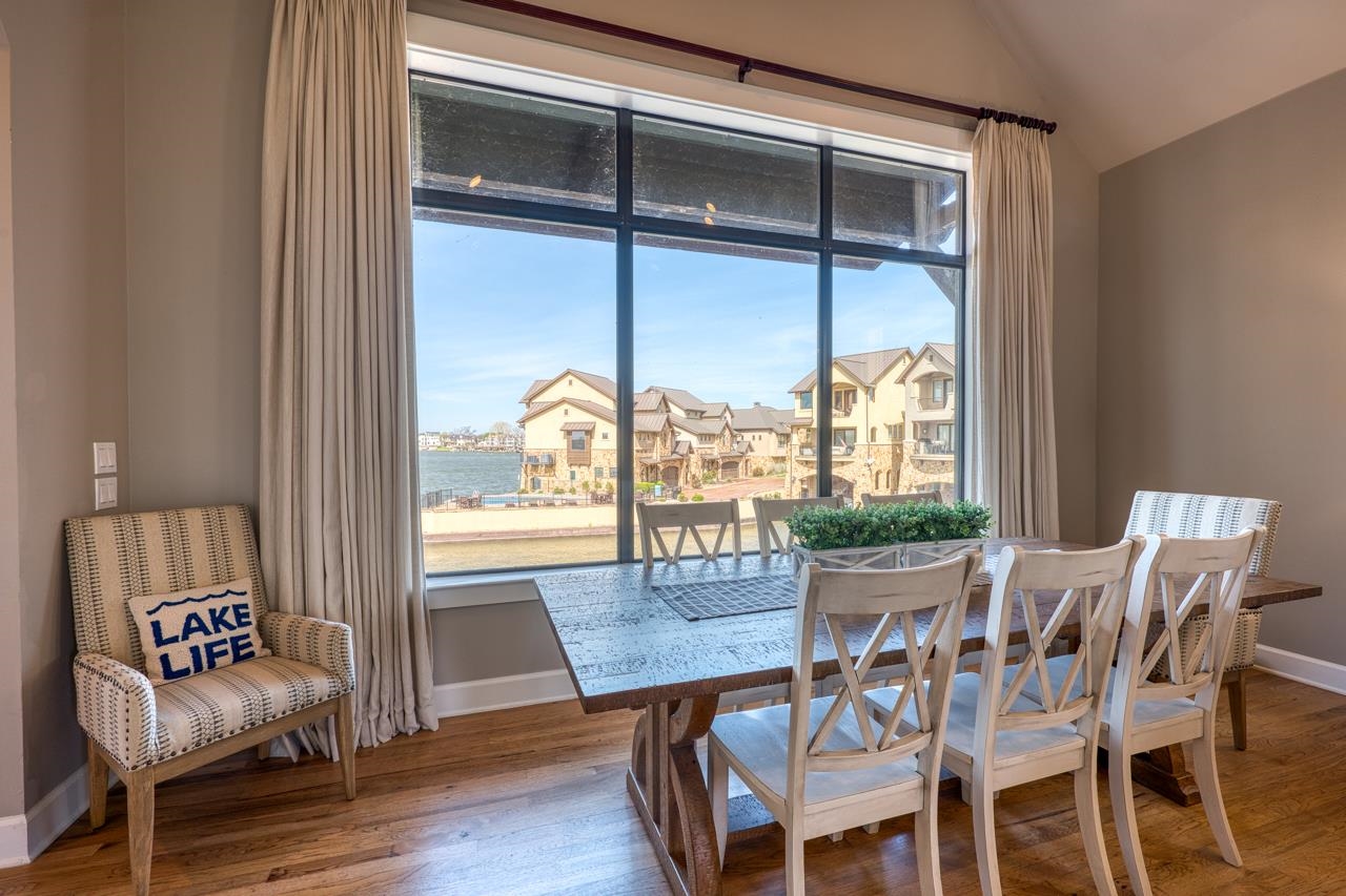 Dining room with a lake view through large windows and a long wooden table.