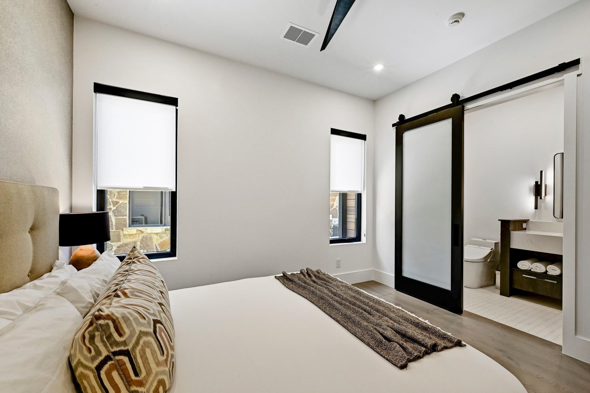 Furnished bedroom with a barn door opening to an ensuite bathroom.