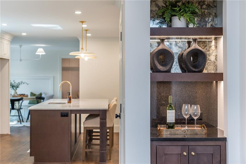 Kitchen with a dark wood island and an illuminated built-in wine bar.
