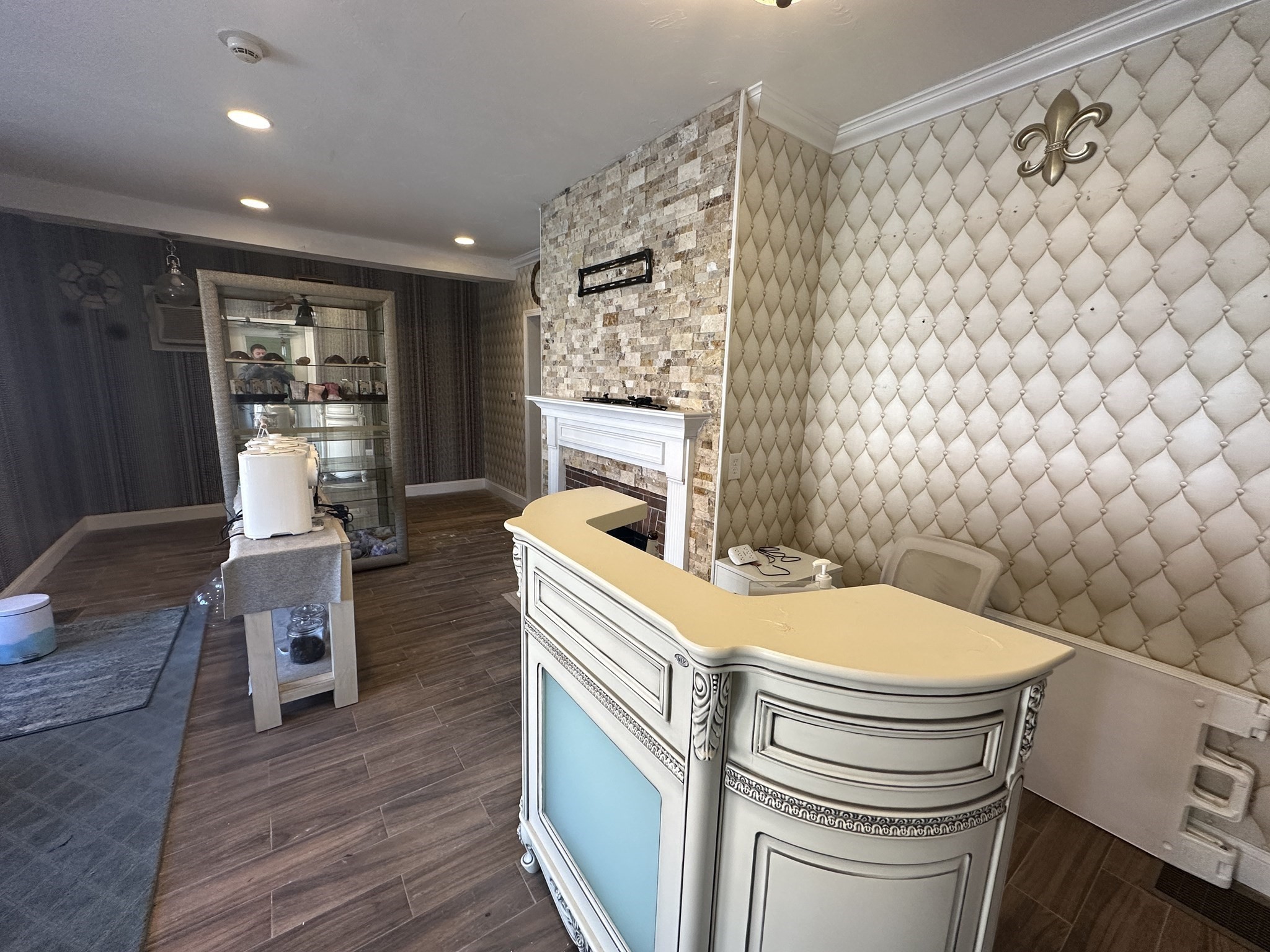 Reception area with an ornate curved counter and stone-faced fireplace.