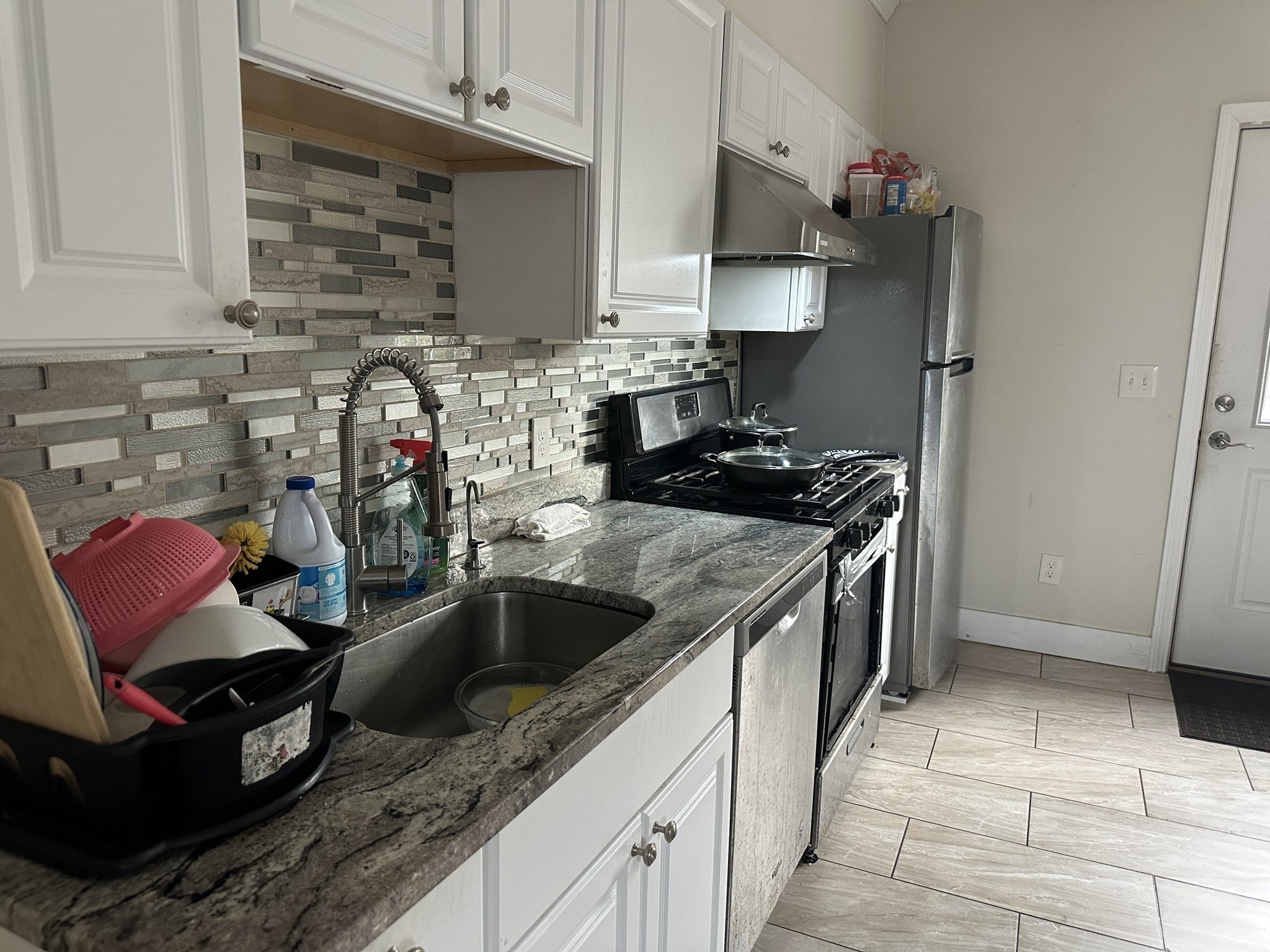 Kitchen with granite counters, a mosaic tile backsplash, and stainless steel appliances.