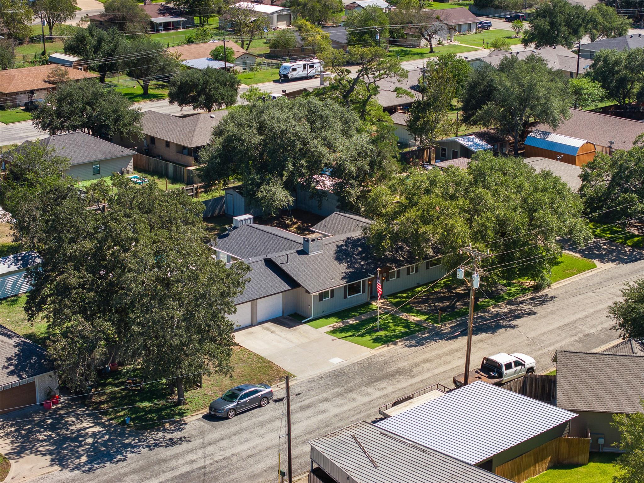 Aerial view of 364 Woodland Ave, a single-story home with a driveway and mature trees.