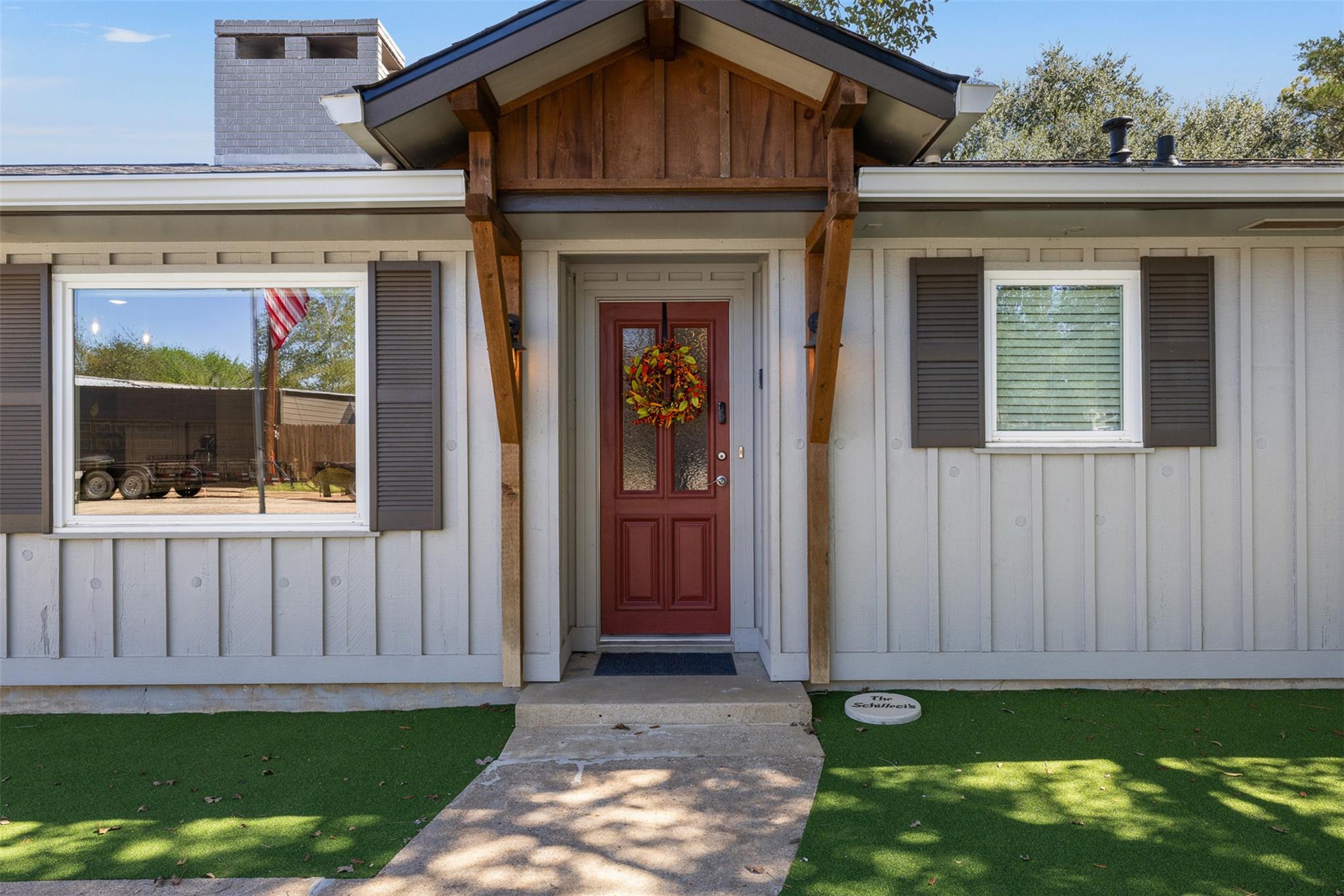 Home entrance with a red double door beneath a timber gabled porch.