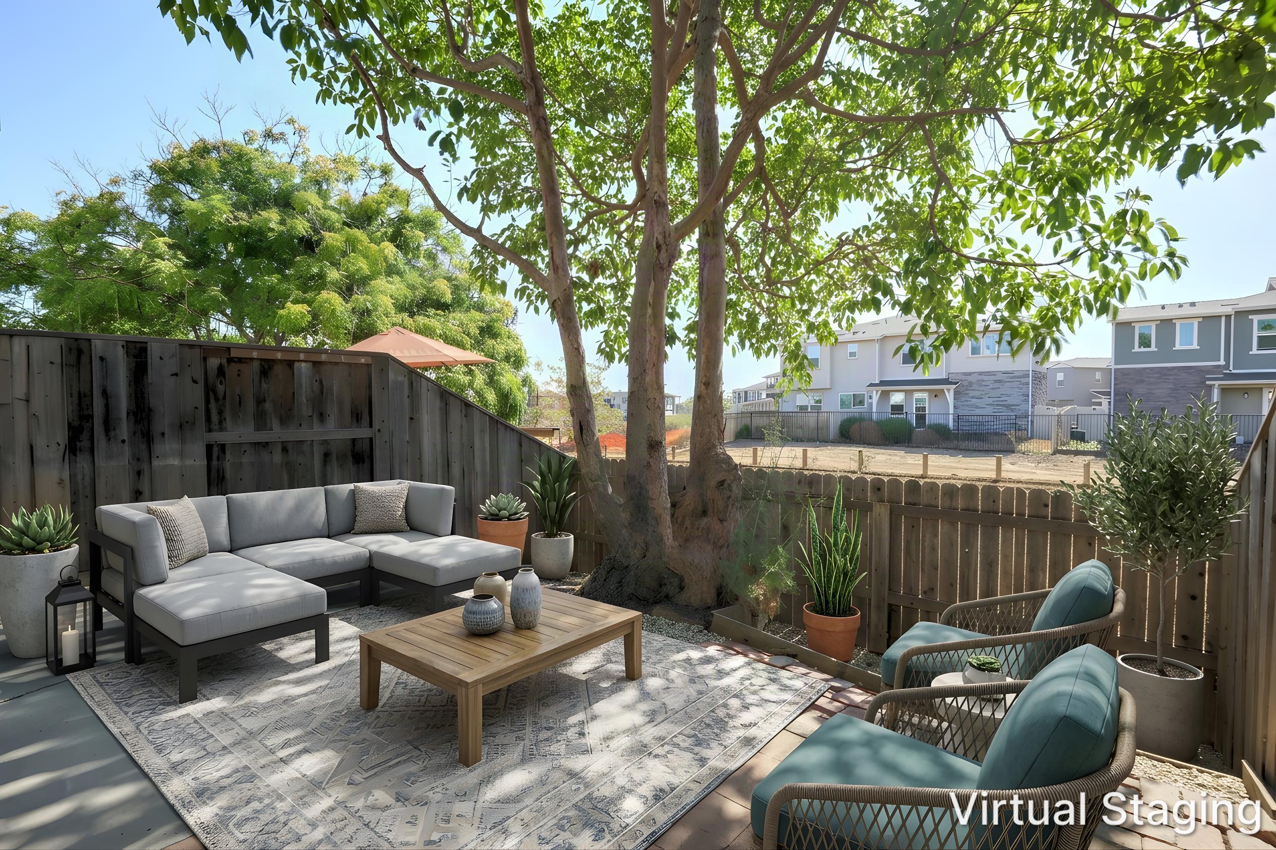 Furnished patio with a gray sectional, blue chairs, potted plants, and a large shade tree.