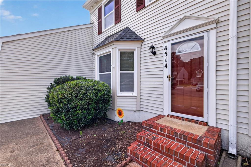 House entrance with red glass door, brick steps, bay window, and number 4514.